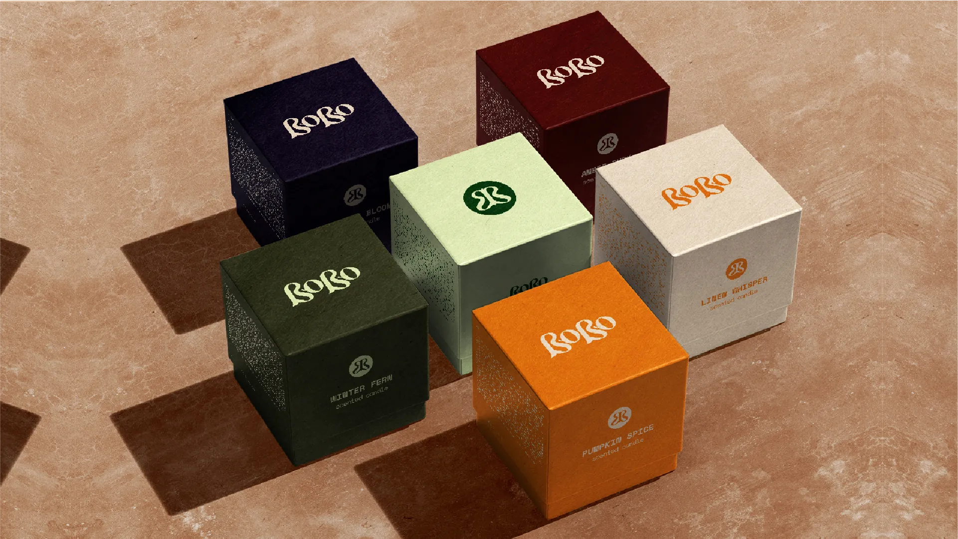 Bobo's candle boxes across six scents, each in a different colourway with the wordmark on the lid.
